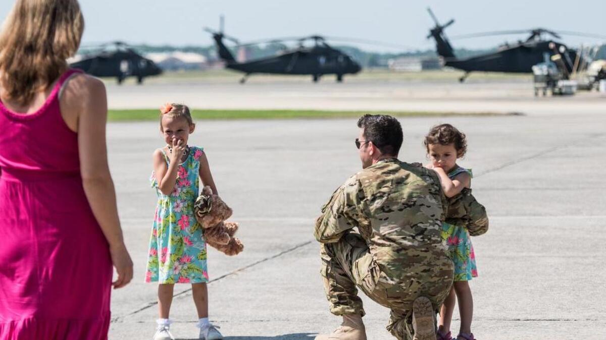 Rebekah Seeger walks toward her husband, Chief Warrant Officer 2 John Seeger, and their two daughters, Scarlett Seeger, left, and Autumn Seeger, right, Friday morning at McEntire Joint National Guard Base in Hopkins, SC. The South Carolina National Guard deployed about 60 crew members and 10 Blackhawk helicopters to Kuwait for one year.