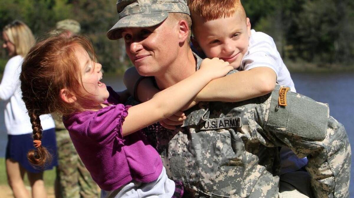 Maj. Lisa Jaster holds her daughter Victoria, 3, and her son Zachary, 7, following Ranger School graduation ceremonies in Columbus, Ga.