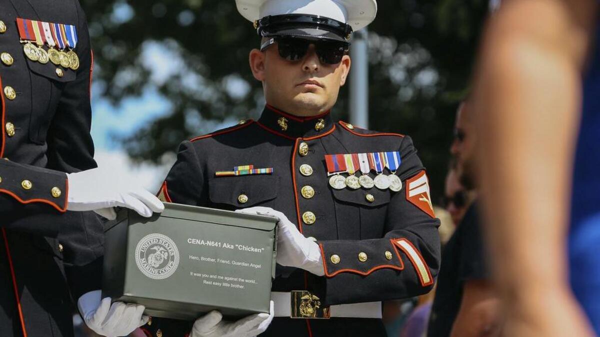 U.S. Marine veteran Lance Cpl. Jeff DeYoung, center, carries the ashes of his dog, Cena, with John North during a funeral service for the 10-year-old military service dog at the Michigan War Dog Memorial in South Lyon, Mich., on Saturday.