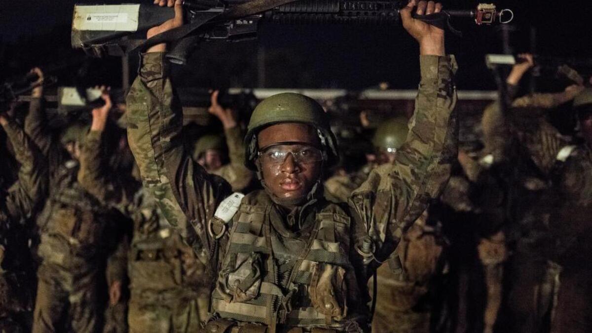 Recruits hold their weapons above their heads during a Night Infiltration Course Thursday, Aug. 4, 2016, at Fort Jackson in Columbia, S.C. The nighttime training uses live machine gun fire as recruits crawl towards a target over a sand obstacle field approximately 200 yards in length.