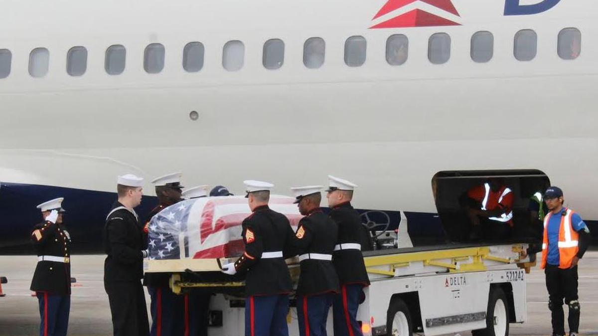 Servicemen unload the casket carrying the remains of Sgt. John Charlton Holladay from the cargo hold of a Delta commercial flight on Friday in Charleston. After more than 72 years, Holladay’s remains were found on Feb. 24, 2015, and properly identified through DNA technology.