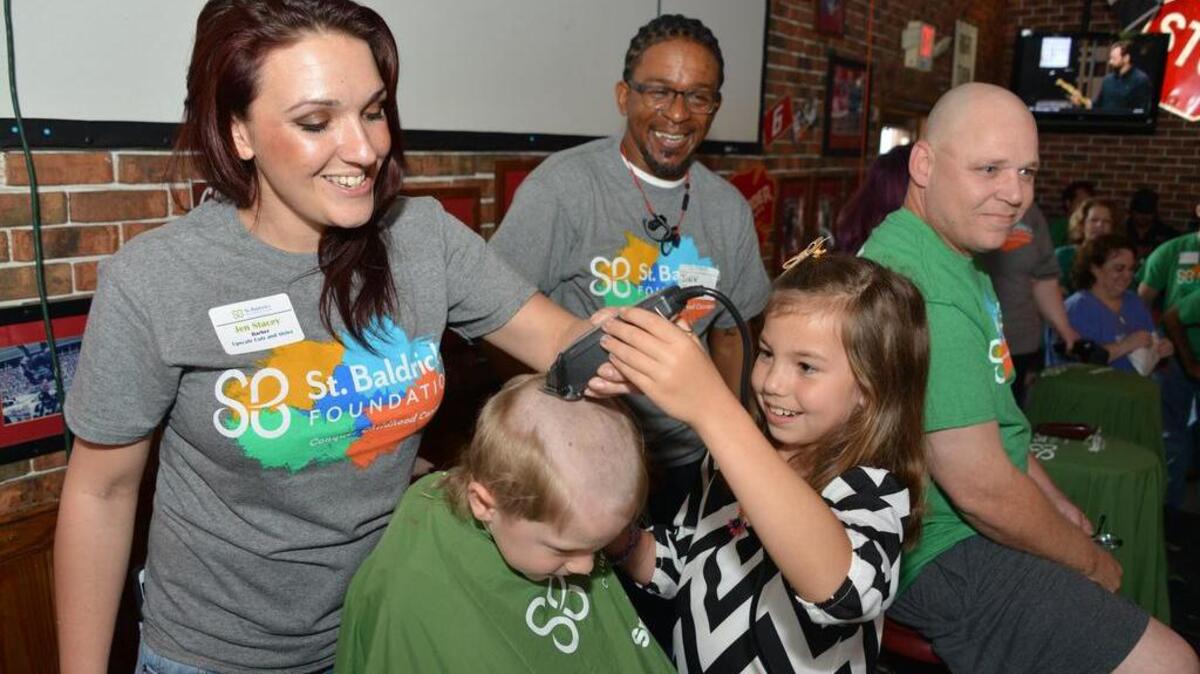 People get their head shaved bald during the St. Baldrick’s Foundation fundraiser on Saturday at Carolina Ale House in Columbia’s Vista. Here, 7-year-old Ellie Beers helps shave the head of her 5-year-old brother, Jack, head with the help of barber volunteer Jen Stacey to raise money for childhood cancer research.