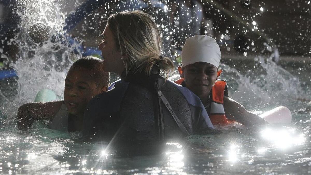 
Courtney Gmerek of The Swim Lessons Company teaches then-7-year-olds Raymond Shiver and Diamond Drummond how to kick during swim lessons at the Drew Wellness Center in 2013.
