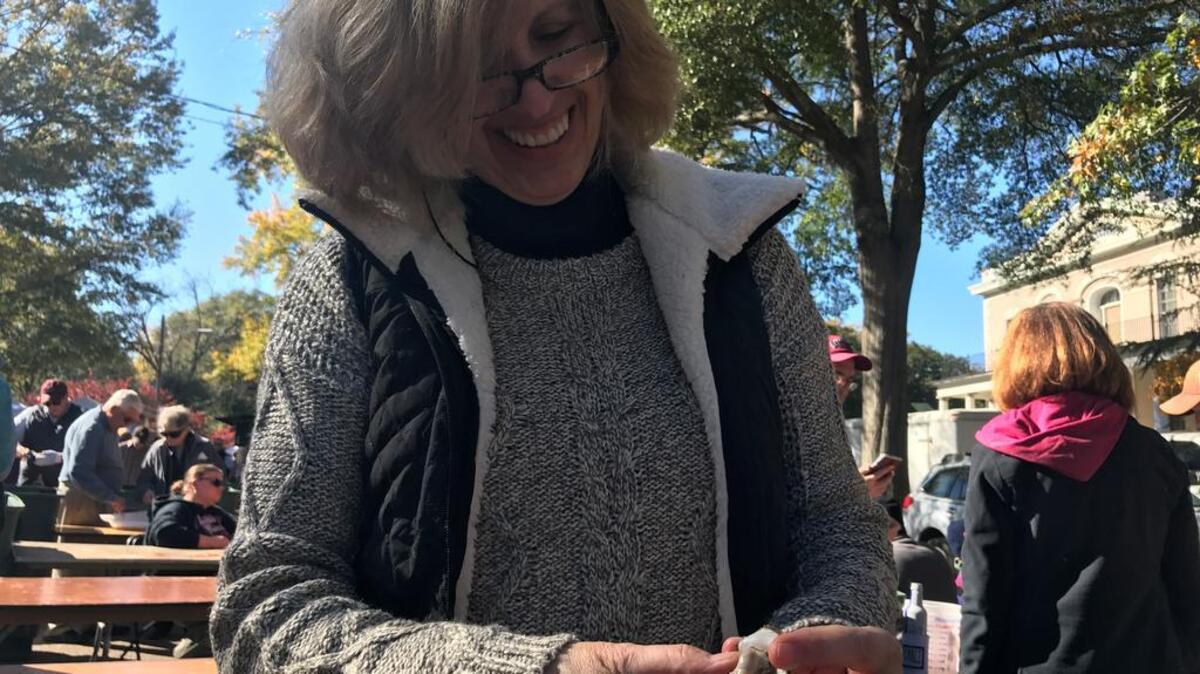 Linell Goodall uses her husband’s knife to pry open oysters at Sunday’s festival.