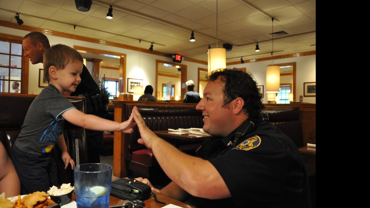 
Batesburg-Leesville resident deputy, Jacob Hallman, exchanges a high-five with a youngster during the Cops and Calabash fundraiser. 
