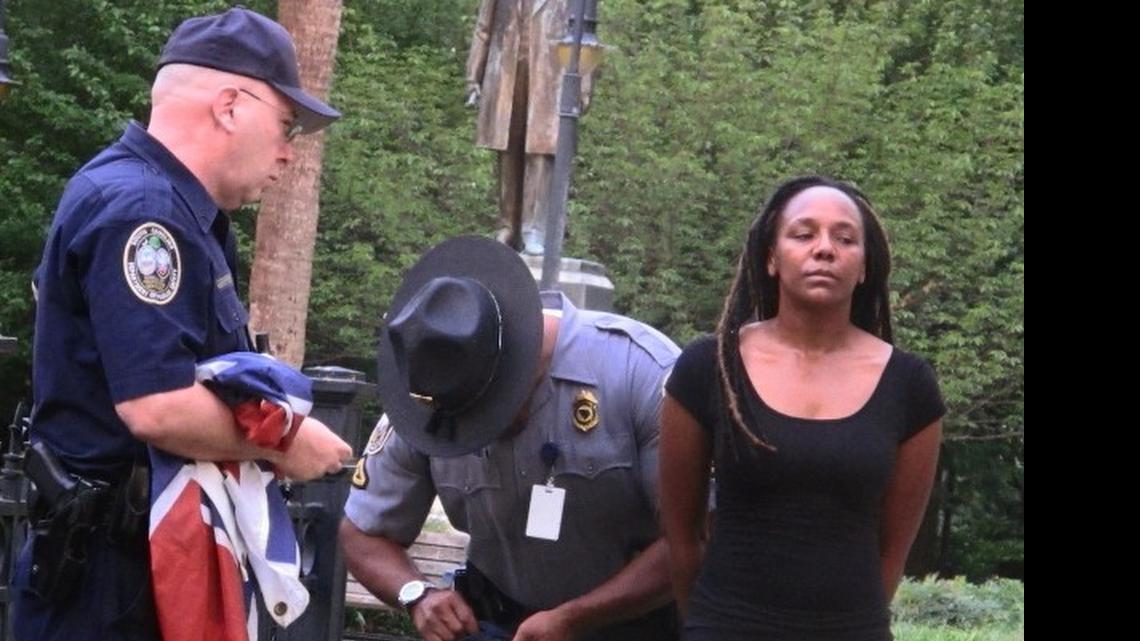 
Bree Newsome of Charlotte, right, is taken into custody after she removed the Confederate battle flag from a monument in front of the S.C. State House early Saturday morning. The flag was raised again by capitol workers about 45 minutes later. 

