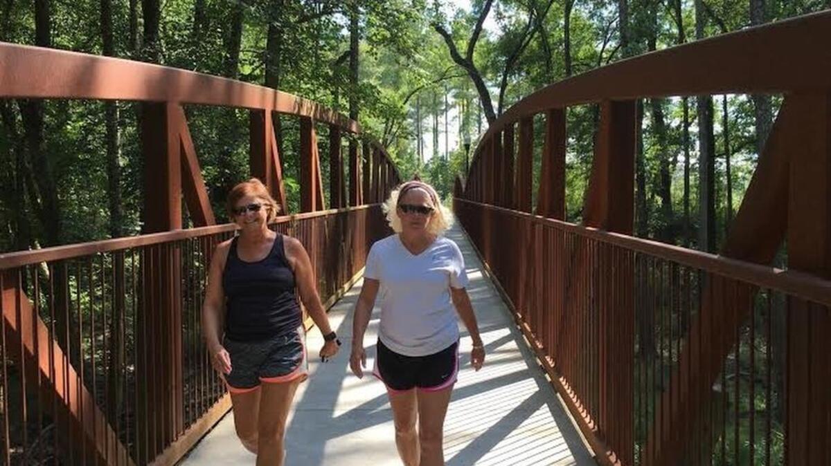 Friends Jeannie Aull (left) and Betsy Hutton walk the trail along Congaree Creek in Cayce to exercise and stay in touch.