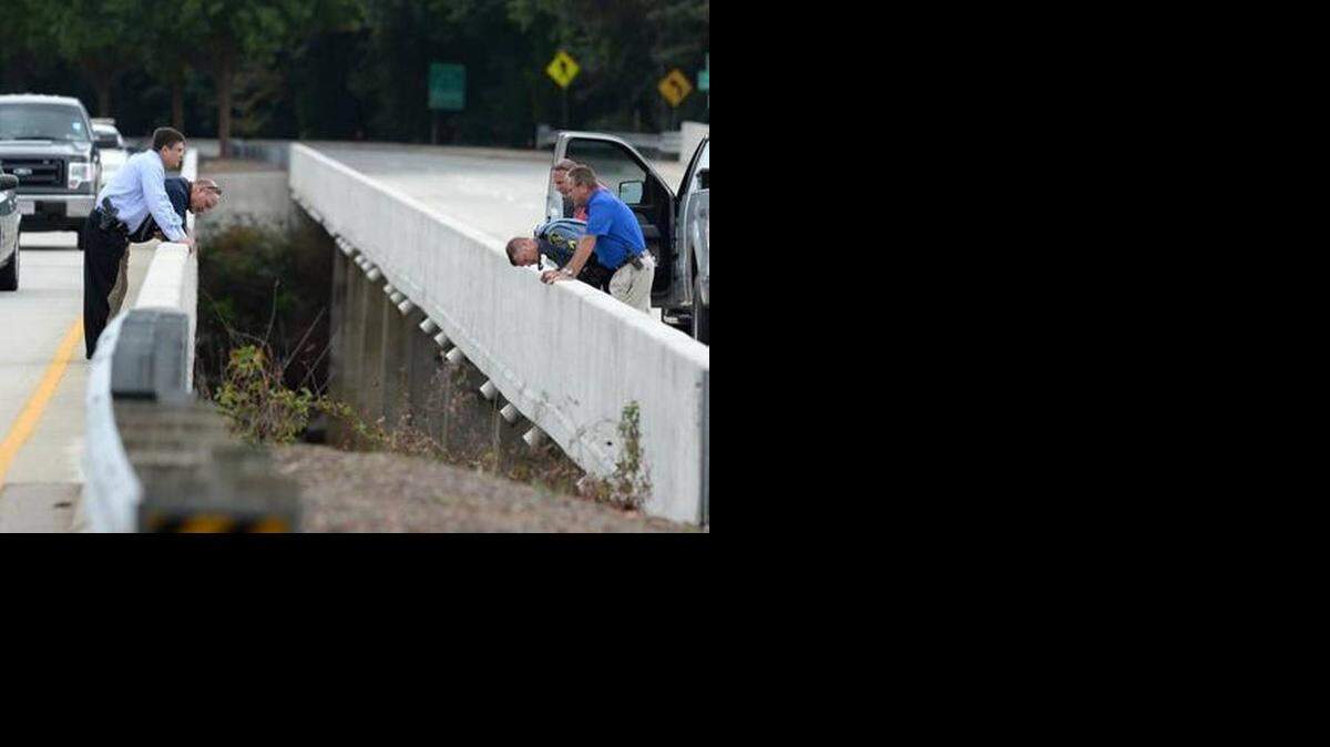 
Investigators look over the bridge on State 93 over the Seneca River in Clemson Tuesday, September 23, 2014 where the body of Clemson student Tucker W. Hipps was found. 
