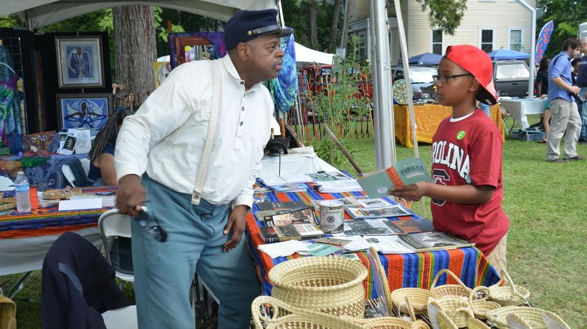 
Civil War reenactor Donald West, of Charleston, talks with 9-year-old Kendall Oglesby about items on display at the Jubilee festival. 
