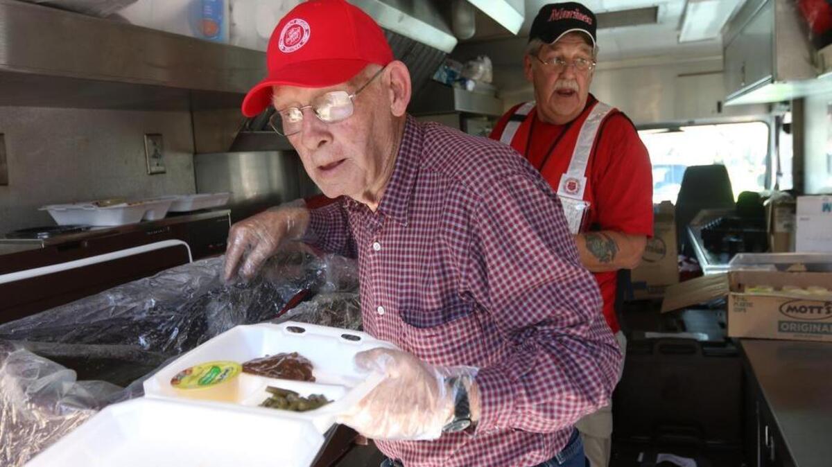 
Bobby Decker and Richard Bosteen serve meals from a Salvation Army food pantry at Eastover Park. 
