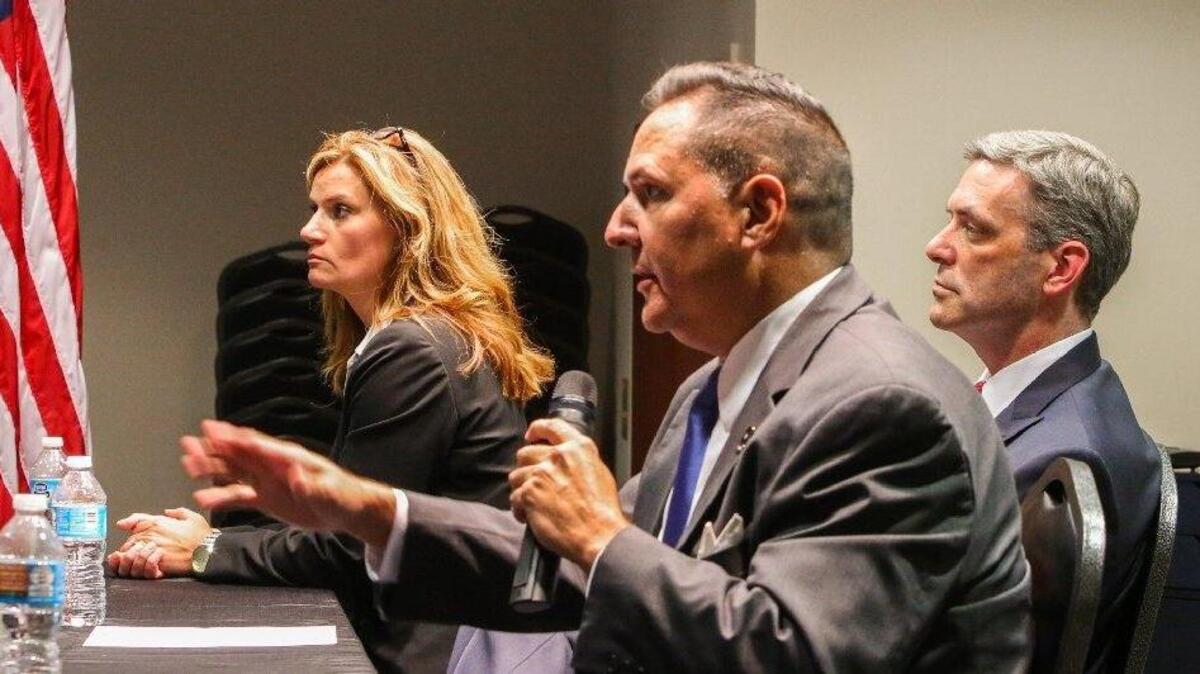 Solicitor candidate Larry Wedekind ( in front) talks while Rick Hubbard and Candice Lively listen during a forum in Chapin May 31.