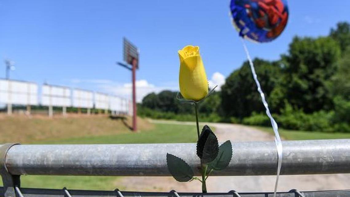 A yellow rose and a balloon are attached to the fence at the Greenville-Pickens Speedway in Easley on Saturday.
