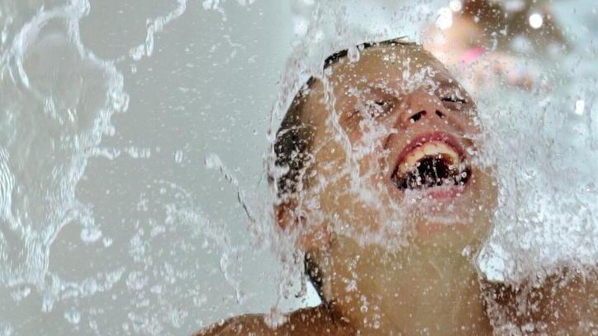 A child stands under cascading water at Fort Jackson’s Palmetto Falls Water Park in 2016.