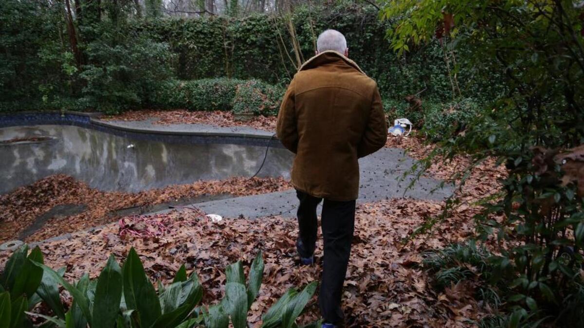 David Pointer, 71, walks outside his flood-damaged home in the Challedon neighborhood off Piney Grove Road on Friday.