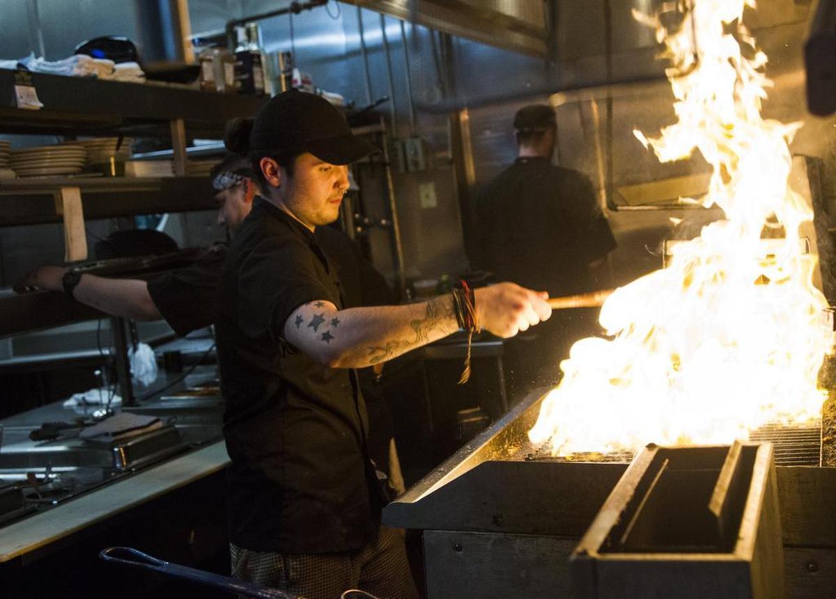Robb Traylor, a sous chef, prepares a steak for an entree dish to be sent out to a customer at Saluda's. Saluda's is one of the few upscale restaurants left in Five Points.