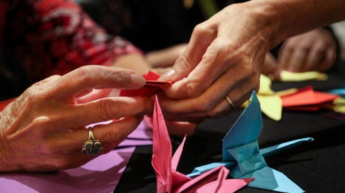 
Cassandra Fralix helps Catherine Combier-Donovan make a paper crane during the Hiroshima Peace Vigil at the Columbia Museum of Art. The Columbia Friends Meeting (Quakers) and the Carolina Peace Resource Center hosted the event which included a performance by the South Carolina Philharmonic String Quartet.
