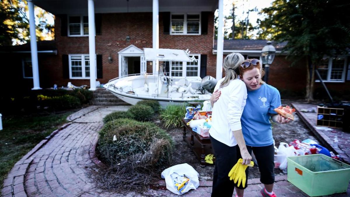 Beverly steinhaus hugs Carol hill, a friend who helped clean her house on burwell st after it was submerged in flood water. During the flood, a boat ended up on their front porch after a neighbor was saving flood victims from their homes.
