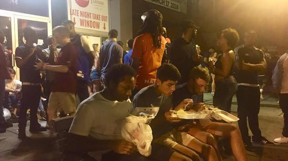 People line up at the Grilled Teriyaki takeout window on Harden Street for late-night food.