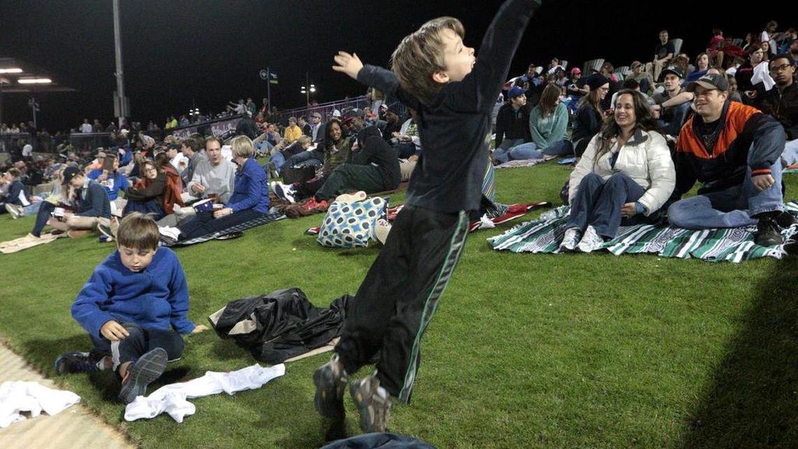 Landon Nieto, 6, and his cousin Hayden Geib, 9, frolick on the Bojangles' Berm with Tammy and Eric Nieto on opening night of Spirit Communications Park.