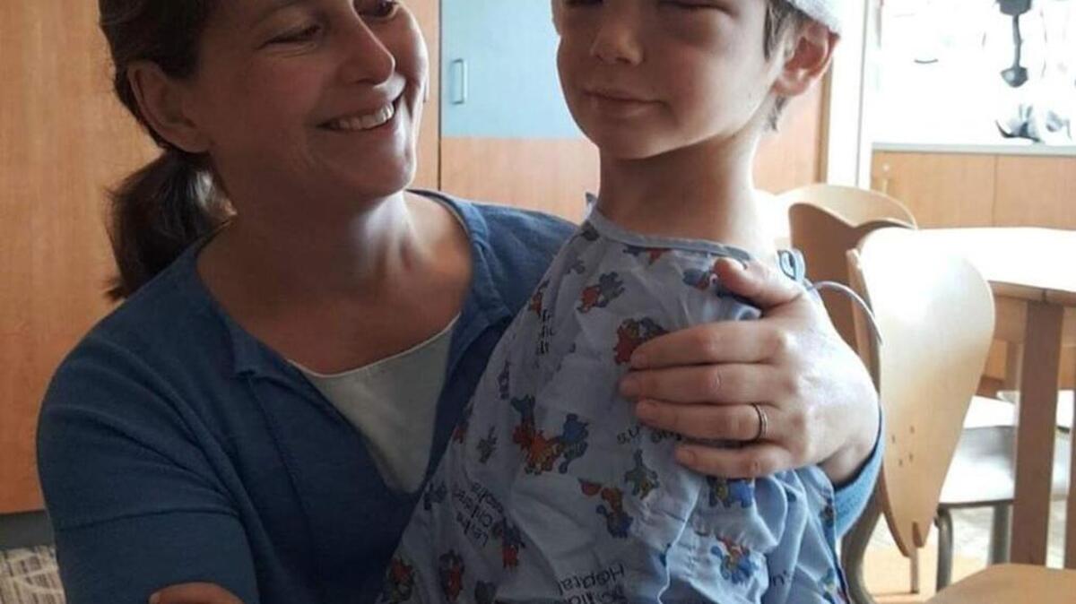 Elizabeth Bertrand and her 7-year-old son, Noah, at Levine Children’s Hospital. Noah got reconstructive surgery at the hospital after he was attacked by three bull terriers Friday.