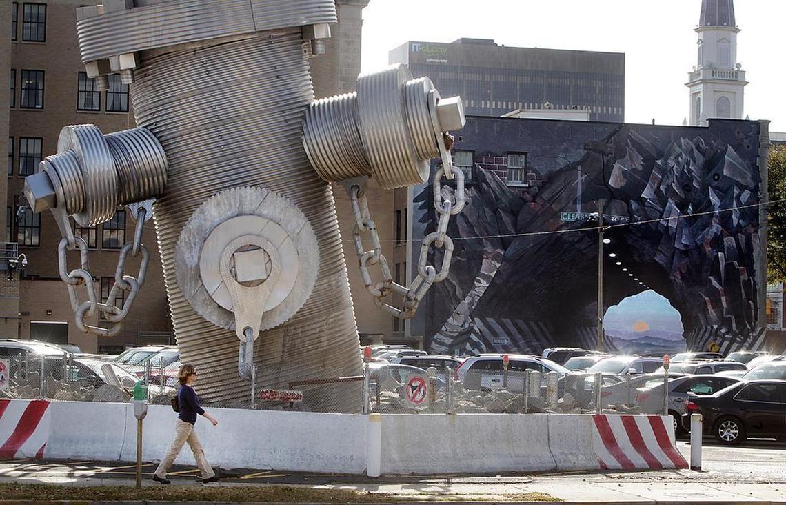 The Busted Plug sculpture, where it sat on Taylor Street before the property was sold for development and the 40-foot fire hydrant was donated to the city of Columbia. In the back is “Tunnelvision,” the mural on the Agfirst building also created by the Busted Plug artist, Blue Sky.