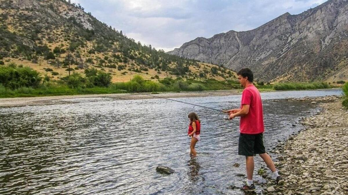
Ehren Sorenson, of Missoula, fishes for trout in the Jefferson River a few miles below the Golden Sunlight mine in Montana as his daughter takes a swim. He said gold mines should contain pollution to protect rivers.
