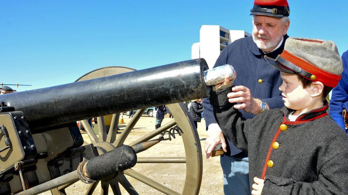 Dwight Backman, left, shows Caleb Meyers how Civil War soldiers loaded their cannons at a reenactment in 2014.