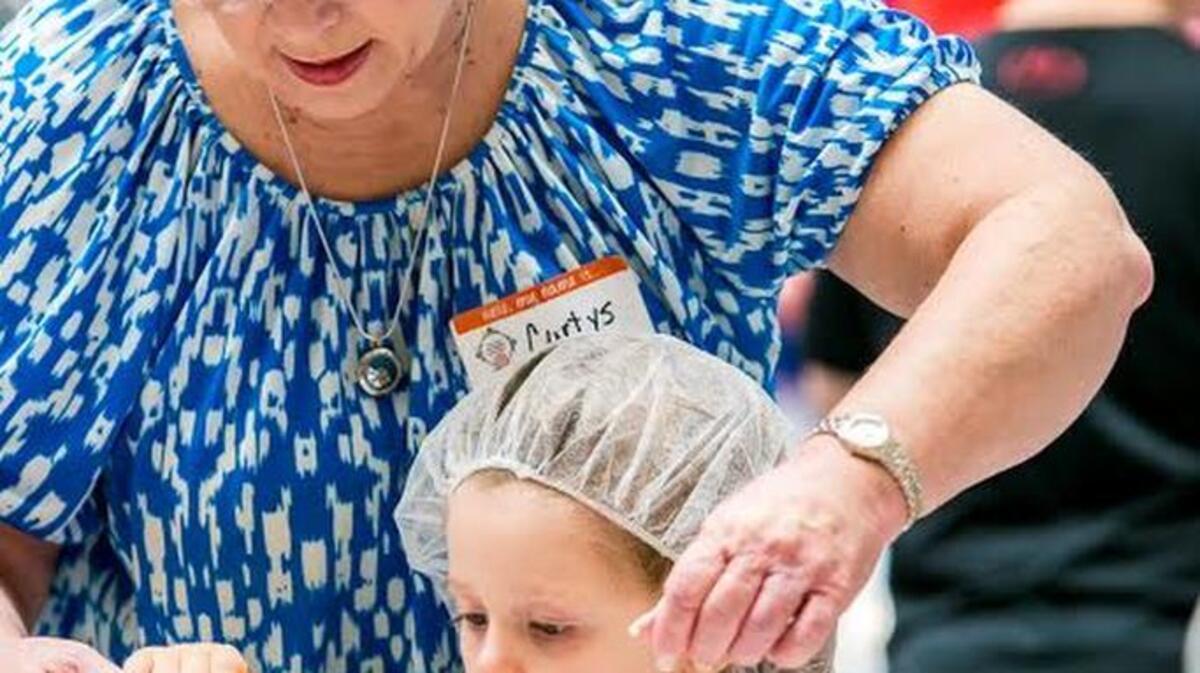 
Lily Grace Collins, 5, gets a little help from Curtys Quesinberry as the Spring Valley Baptist Church members fill bags with lentil soup mix for the hungry on Saturday. Lily Grace’s mother, Dorothy Collins, said she was trying to teach her daughter about helping people in need. “We’re doing it so she understands that other people do not have food and are hungry.”
