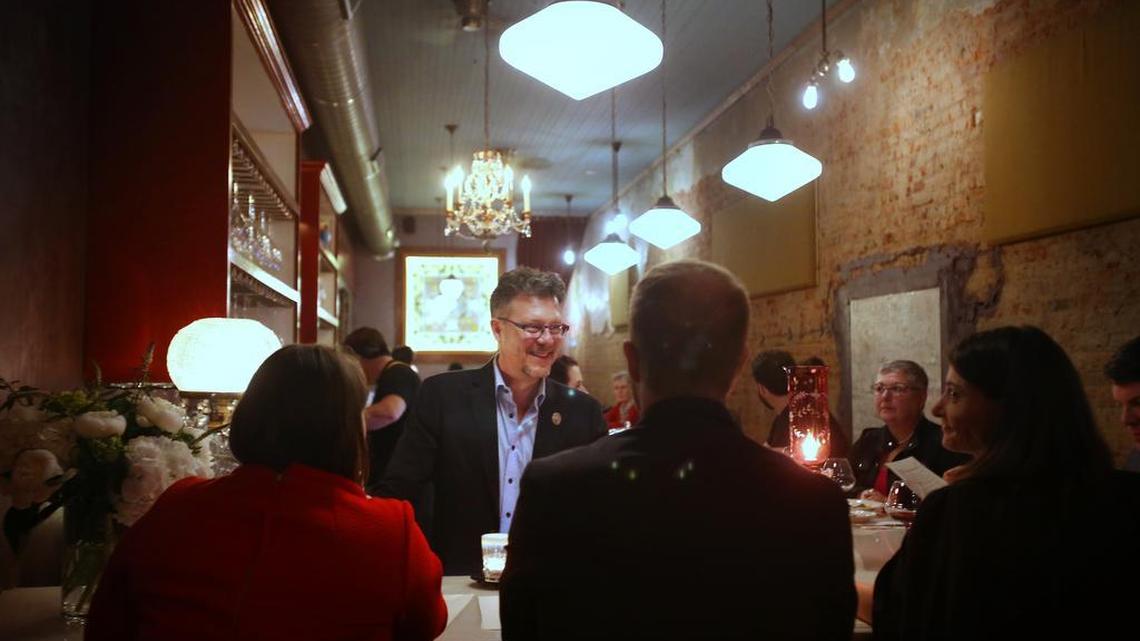 Tim Gardner, co-owner of Lula Drake Wine Parlour, talks with customers as they enjoy wine.