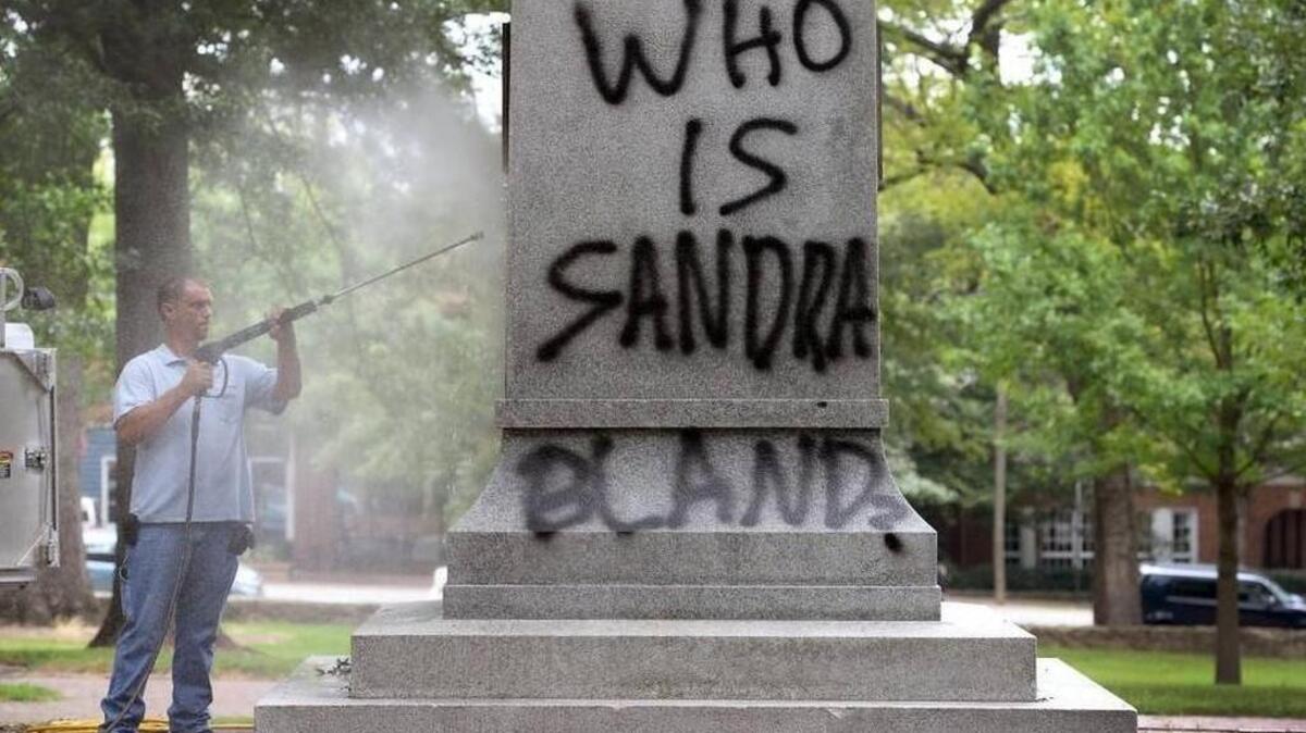 
UNC Facilities worker Chris Moore uses a pressure washer to try and remove spray paint from the Confederate War Memorial on the campus of UNC-Chapel Hill Tuesday, August 18, 2015. The memorial was vandalized in early July by protesters after the Charleston massacre. 
