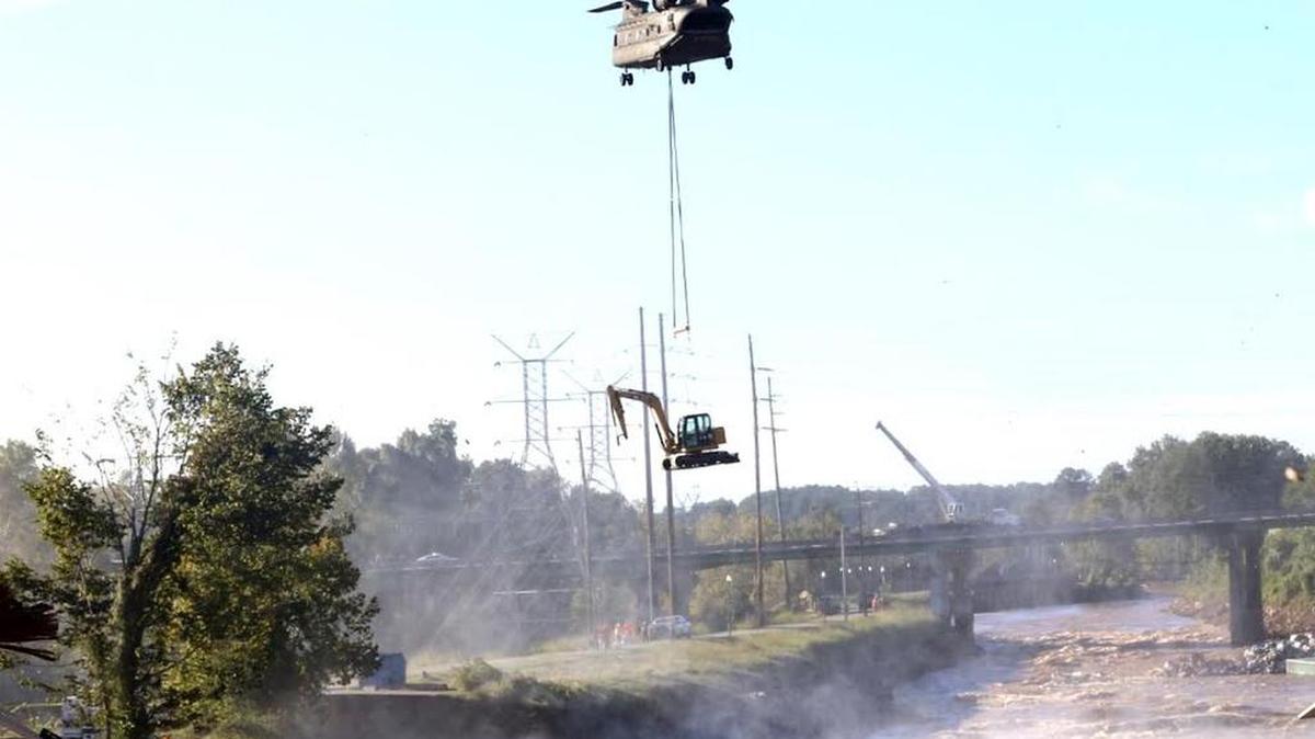 
A Chinook helicopter from the S.C. National Guard hovers over the Columbia Canal Tuesday as it moves into position with equipment needed to repair a gashed dike.
