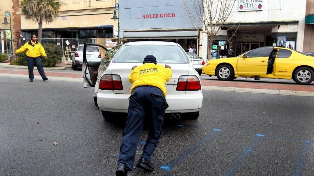 Among the functions that downtown yellow shirts do is help motorists whose car has stalled.