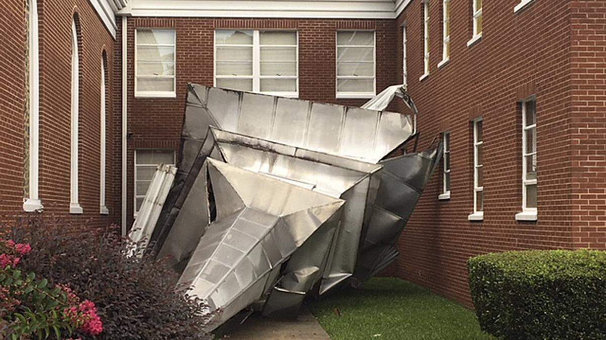 In this Monday, Aug. 6, 2018 photo, the steeple at Langley First Baptist Church is seen on the ground after a strong storm moved through the area, in Langley, S.C.  (John Boyette/Augusta Chronicle via AP)