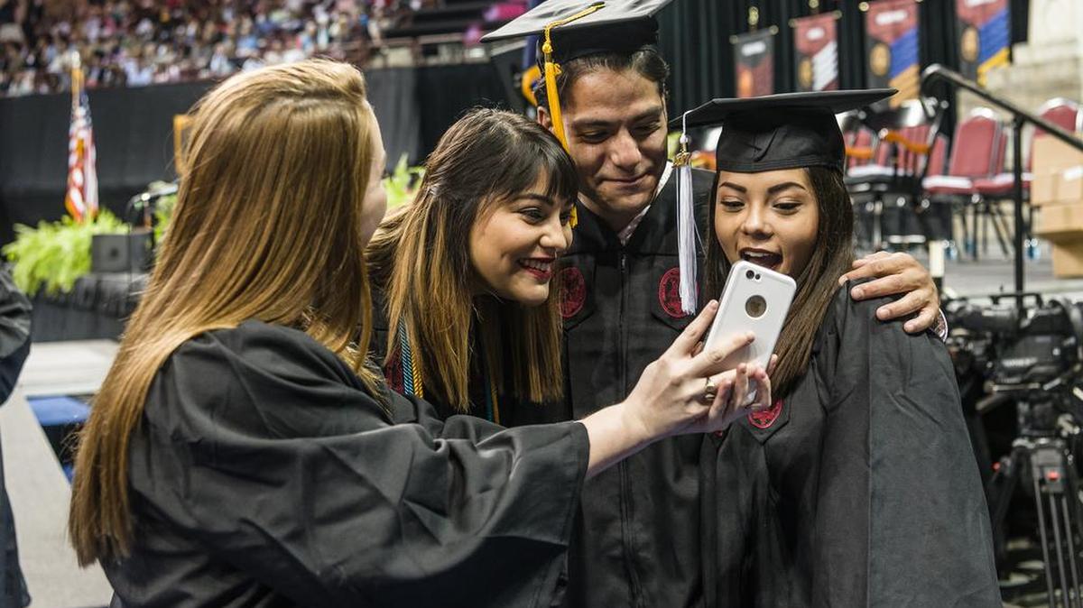 University of South Carolina graduates talk with one another before the beginning of their graduation ceremony held at the Colonial Life Arena.