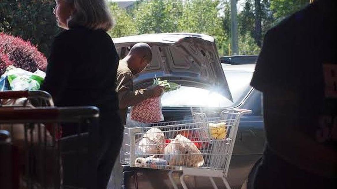 
Families put food into their cars at a drive-through opened Tuesday at Harvest Hope food bank in Columbia.
