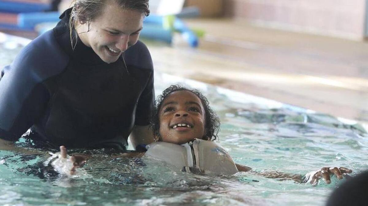 Courtney Gmerek teaches Zhyairiyah Blackwell, then 7, how to float during swim lessons at the Drew Wellness Center in 2013.