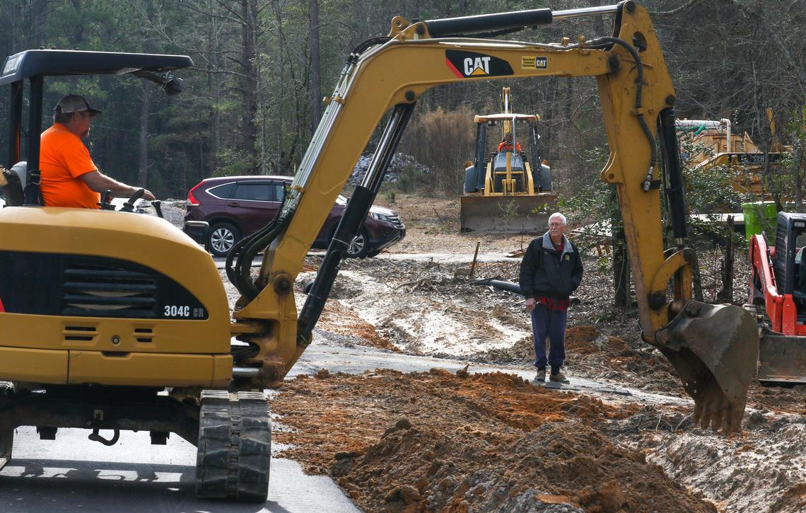 A county resident watches construction of a road project funded by taxpayers as part of the Richland County Penny Tax program.