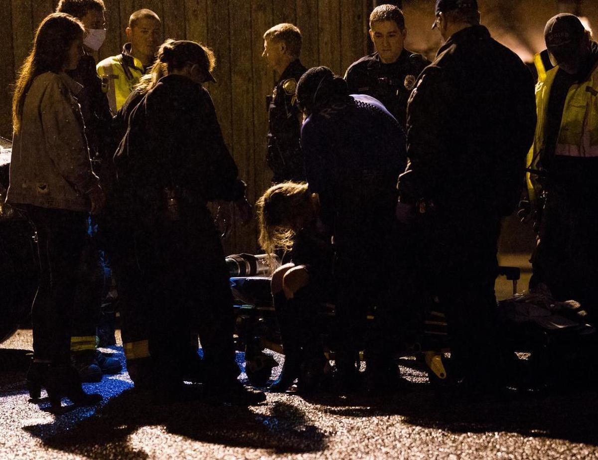Emergency first responders treat a woman in a parking lot next to Moosehead Saloon.
