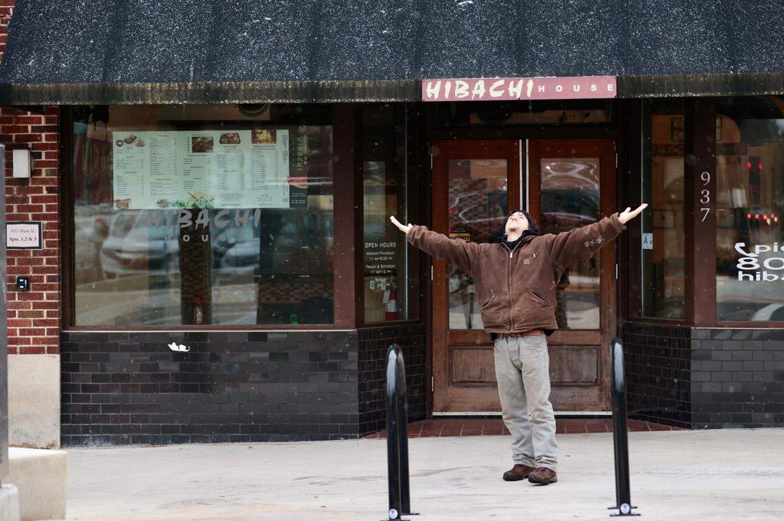 Travis Casanova celebrates the light flurry of snowflakes outside Habachi restaurant in Columbia on Jan. 21, 2025.