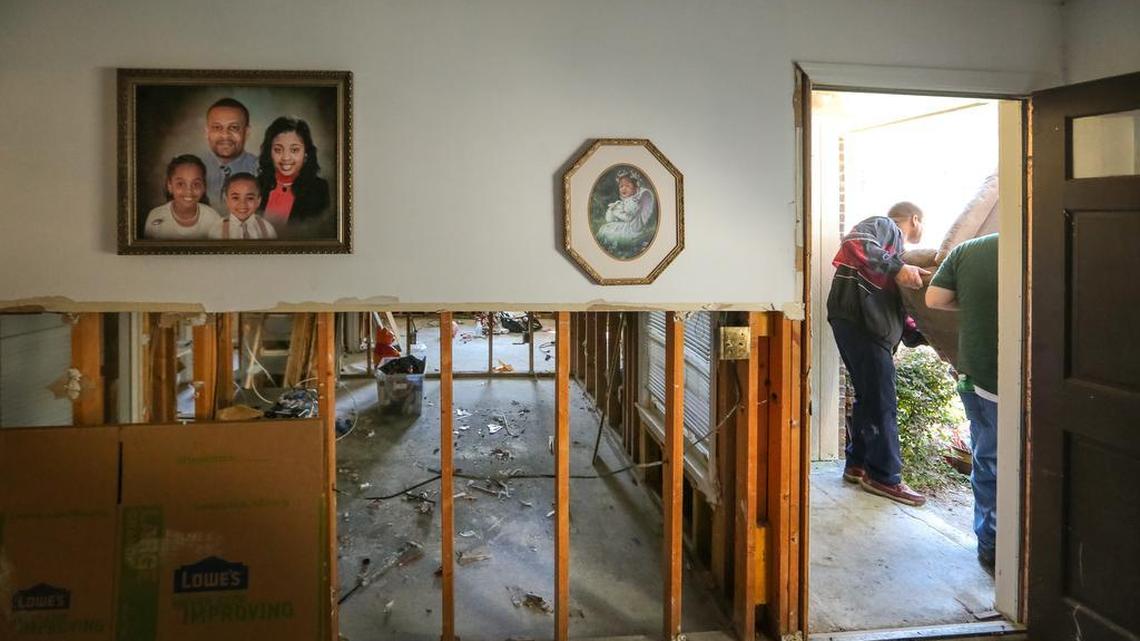 Sam Fant gets help removing a couch from his Pine Glen neighborhood home. His home was flooded when SCEG released water during the heavy rains. Nearly all the residents think that they didn't have enough warning and that SCEG should help pay for their loss.