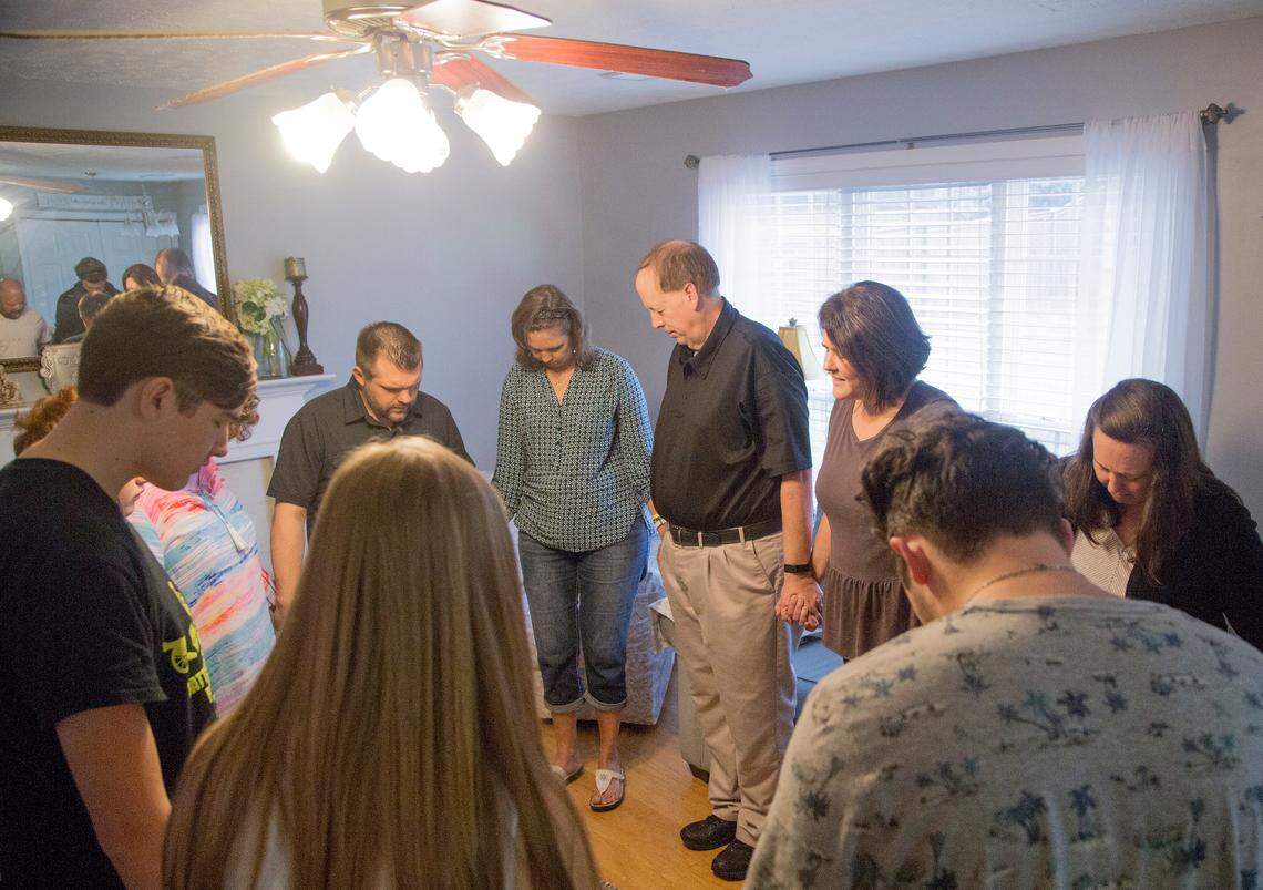 Family and friends bow their heads in prayer during a meeting for The Church at West Vista at the home of Pastor Jody Ratcliffe in West Columbia, SC. The Church at West Vista is a house church network which meets at separate homes during the month except for the last Sunday when they go to New Brookland Tavern.
