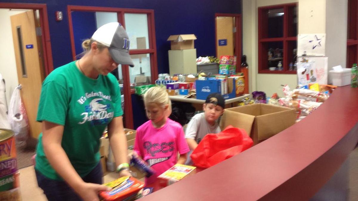 
Volunteers Leslie Mazzei and children Madison and Cameron sort groceries at Seven Oaks Park donated for flood victims
