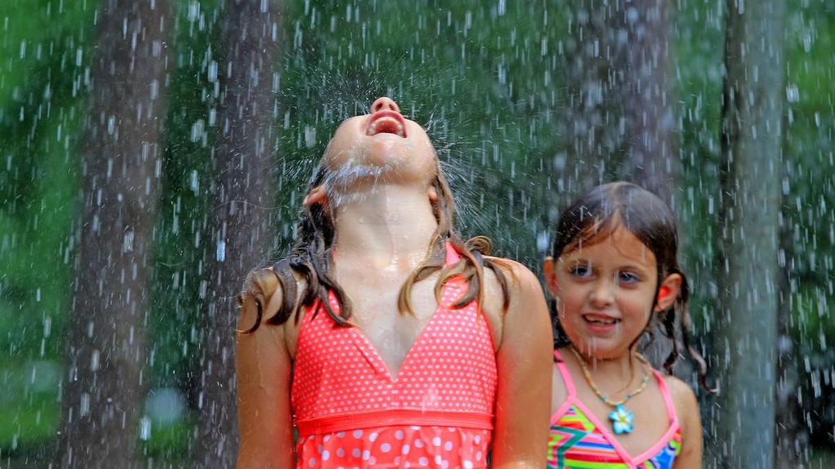 Julia Claire Cook, 7, left, enjoys the spray pool at Heathwood Park with friend Addy Branham, 6, during a hot summer day in Columbia.