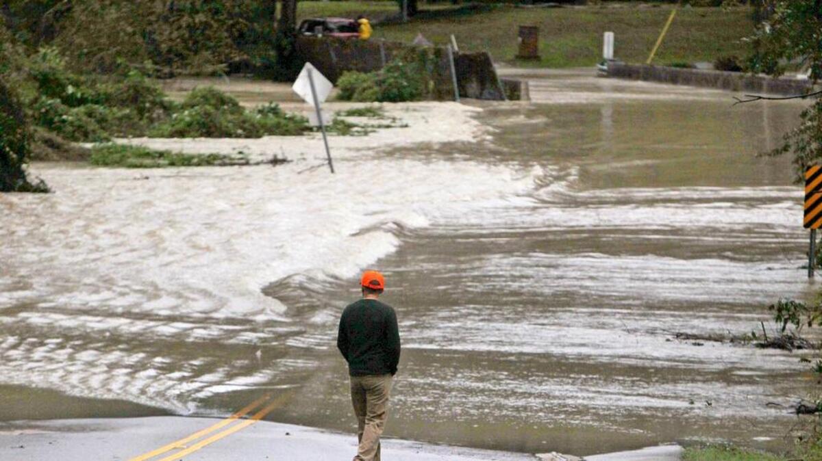 
Zoltan Borbely looks on as water from Gills Creek runs over Kilbourne Road on Monday in Columbia.

