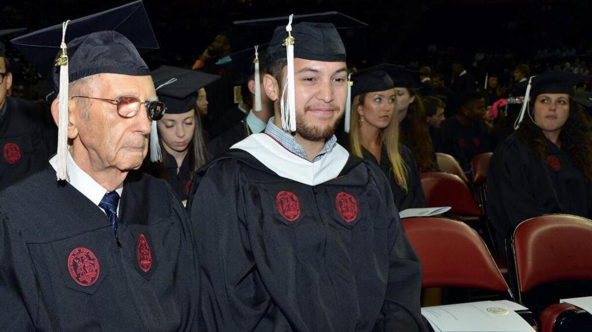 
Dan Brown, an Anderson resident who turns 90 years old this month, received his degree at the Colonial Life Arena on Saturday. He went to Carolina in 1942-43 and again in 1946-47. In between he served in the Army in World War II. He thought he had not finished his degree, but it turns out that “when he checked recently,” he found he had the credits he needed. He earned a bachelors degree in economics from the Darla Moore School of Business. Brown is in good shape but suffers from macular degeneration and is nearly blind, so he had an escort walk him across the stage. Here, Brown sits with fellow graduate Jonathan Poon of Columbia, who received a Master of Applied Statistics degree.

