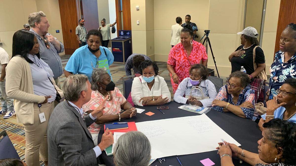 Mayor Daniel Rickenmann sits with a group of residents to answer questions about the city’s planned Hope Center, a homeless services campus leaders hope to build.