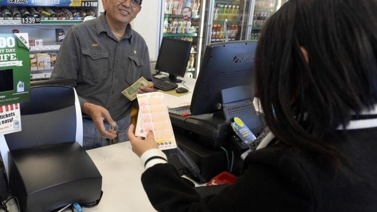 Highland Creek BP cashier Jack Patel gives a customer her Powerball ticket in Charlotte, on Tuesday, January 12, 2016. On Tuesday afternoon the Powerball jackpot rose to an estimated $1.5 billion.