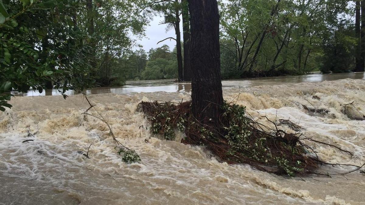 Water pours across the Spring Lake dam in Arcadia Lakes after a dam burst upstream during historic flooding Oct. 4.