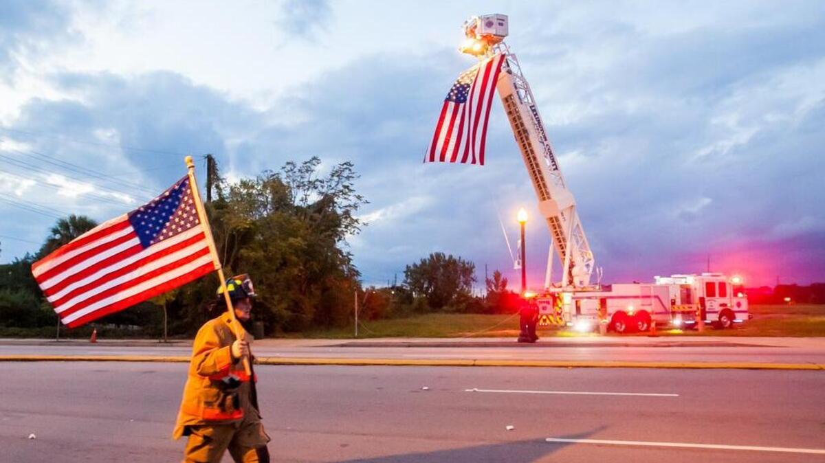 A firefighter walks past Columbia Fire Department's Ladder 10 on Gervais Street during the 2014 Tunnel to Towers 5K Run & Walk in honor of Stephen Siller, a New York City Firefighter.
