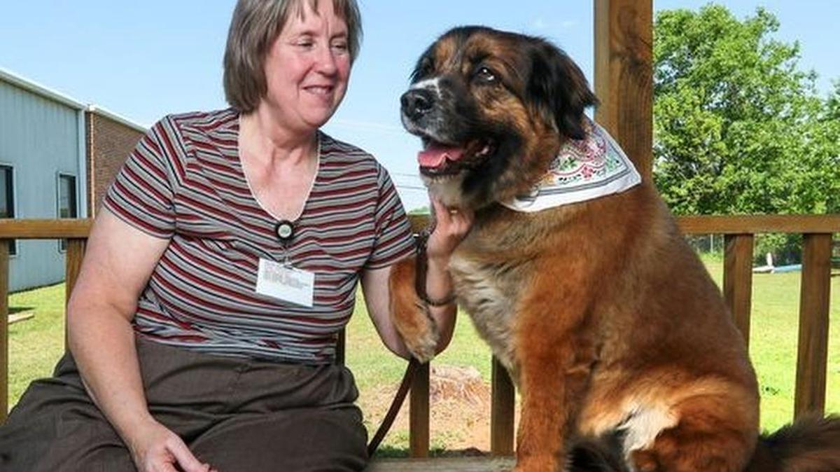 Judie Cooper and her dog Maggie, who works as a therapy dog during work hours, gets a hug from her at the South Carolina Department of Mental Health's Anderson Oconee Pickens Mental Health Center in Anderson.